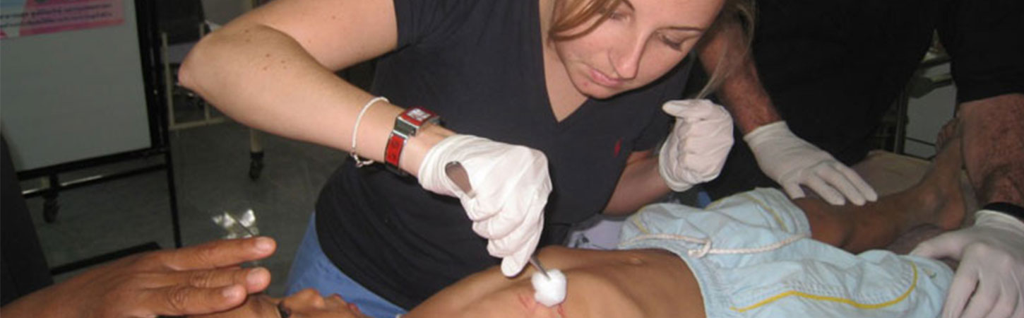 Intern applying medicine to a wounded child